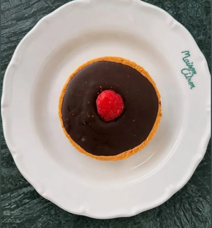 Tarte chocolat-piment et framboise, vue de dessus sur marbre vert foncé.